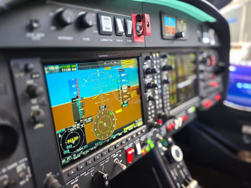 Detailed view of a modern airplane cockpit featuring advanced Garmin navigation displays and controls.